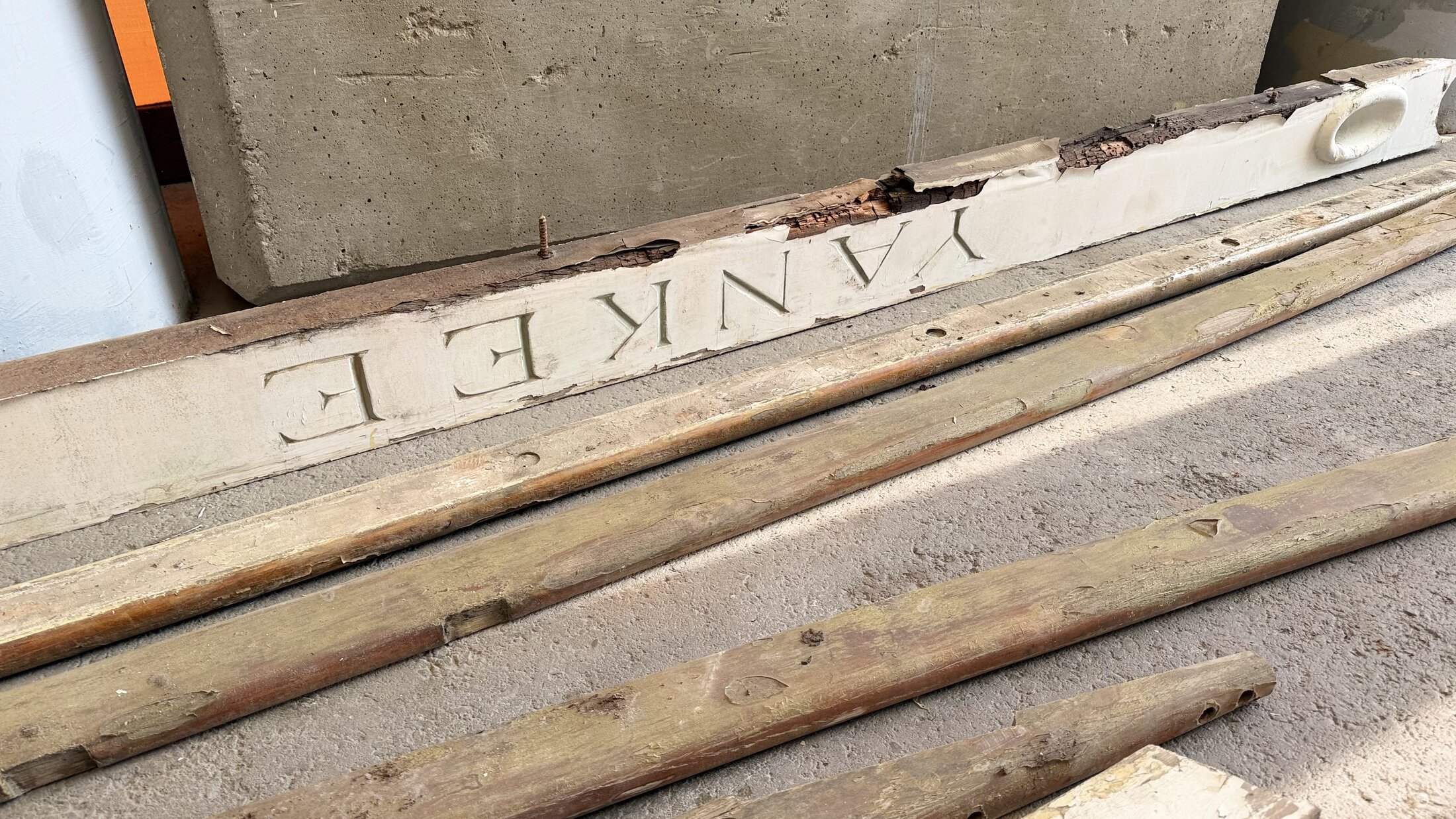Yankee's carved name board and long trim pieces laid out during the move